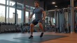 © fotofabrika - Fitness enthusiast performing a dynamic leg exercise in a modern gym during daytime, focusing on strength and agility training