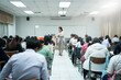 © EduLife Photos - A teacher carefully monitors students taking an exam in a classroom, ensuring focus and discipline during academic assessment.