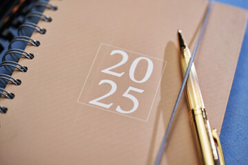 2025 brown diary and gold colored pen on blue color file