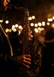 © Alexandra - Saxophonist performing live jazz music on stage with bokeh lights in the background