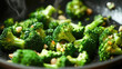 © Suphawan - A close-up of broccoli florets sizzling in a pan, tossed with olive oil and garlic, showcasing the bright green color and crisp texture of the cooking process.