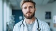 © JK_kyoto - Confident male doctor with stethoscope in a modern medical office setting, serious expression, looking directly at the camera.