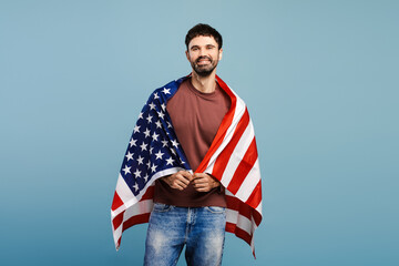 Handsome, smiling man holding American flag looking at camera. USA independence day concept