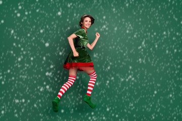 Canvas Print - Photo of energetic lady jump hurry wear elf costume hat striped socks isolated green color background