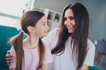 Wall Mural - Photo of cute daughter speaking with mom embracing enjoying time together indoors apartment room