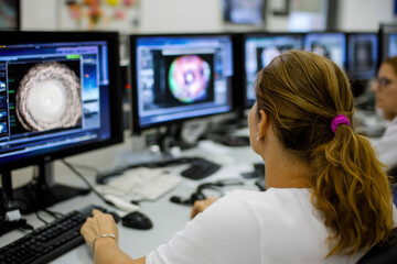 Wall Mural - Meteorologist team monitoring weather forecast at monitor screen in meteorological office workplace. Woman meteorologist monitors formation of dangerous storms, approaching catastrophic hurricane