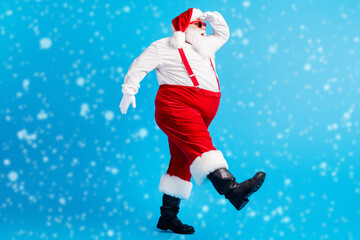 Canvas Print - Full body profile side photo of overweight fat santa claus with big belly beard go copyspace look x-mas christmas ads wear suspenders overall cap isolated over blue color background