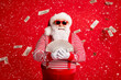 © deagreez - Photo of retired old grandpa hold cash fan prepare spend money newyear charity wear santa costume suspenders sunglass striped shirt headwear isolated red color background