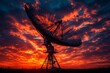 © Liza - Radio telescope silhouetted against a dramatic red sunset sky