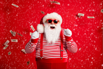 Poster - Photo of pensioner old man grey beard raise fists open mouth money shower wear santa x-mas costume suspenders sunglass gloves striped shirt cap isolated red color background