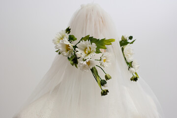 tulle fabric embroidery of flowers and birds on a veil On a thin fabric a woman embroiders straightening beautiful handwork on a mannequin wedding dress with bright decorations