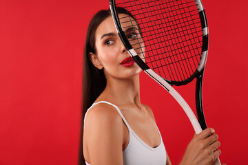 Canvas Print - Beautiful young woman with tennis racket on red background