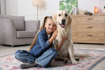 Canvas Print - Girl with her cute Golden Retriever dog on rug at home