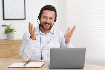 Sticker - Interpreter in headset having video chat via laptop at wooden table indoors