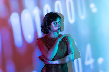 Young woman in colorful lighting with digital background