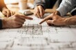 © Kedsara - A closeup of hands pointing to a complex building blueprint, surrounded by engineers and business professionals discussing technical and financial details