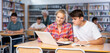 © JackF - European fifteen-old-year schoolgirl, studying with a classmate in the school library on a laptop and making abstract in the copybook, preparing for lessons