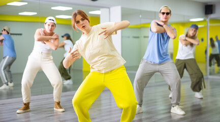 Teen girl in sportswear dancing modern dances in dance studio..