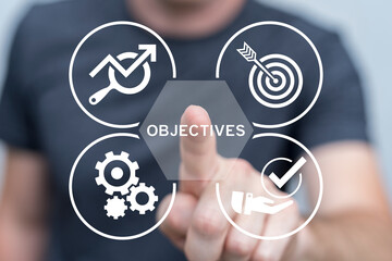 Man using virtual touch screen presses word: OBJECTIVES. Company target achievement, business goal or objective to achieve, team strategy, leadership development, aiming for winning goal concept.