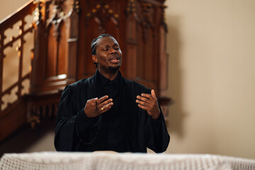 Young priest giving sermon from church altar