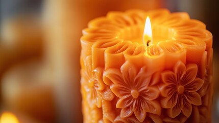 Poster - A beautifully carved orange candle with a lit flame, surrounded by soft lighting.