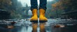 © B8stock - A pair of yellow rubber boots on a rainy path, surrounded by wet leaves and a misty backdrop, perfect for outdoor adventures.