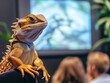 © Suwakrit - A close-up of a lizard in an indoor setting, with blurred people in the background, showcasing a unique pet interaction.