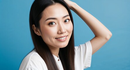 Young Asian woman with bright eyes and long straight hair relaxed soft blue background