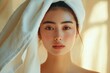 © ryker - beautiful Asian woman with fresh skin and towel on her head, radiating natural beauty and serenity. Her glowing complexion and soft expression evoke sense of calm and freshness
