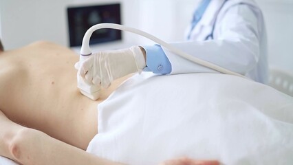 Doctor woman wearing white medical gloves performing ultrasound exam on male patient back. Medicine and healthcare