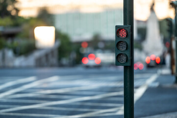 Red traffic light at an urban intersection during twilight hours