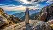 © suchetpong - Thermal bottle on a rock on top of a mountain viewed from below