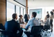 © YiuCheung - A group of people in a meeting room listening to a presenter standing at a table with a whiteboard behind them.