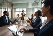 © YiuCheung - A group of business professionals gather around a table to applaud a female colleague in a brown suit who stands in front of them.