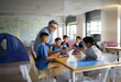 © YiuCheung - A teacher and a group of students working on a robot project in a classroom.