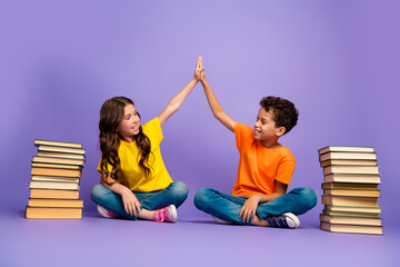 Wall Mural - Full body photo of cute little boy girl books high five dressed stylish yellow orange clothes isolated on purple color background