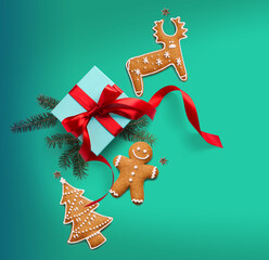 Wall Mural - christmas composition on a blue background with a gift box, with red ribbon, fir branches, homemade 