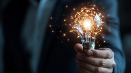 Fototapete - A person holding a glowing light bulb that emits sparkles, symbolizing creativity and innovation in a professional setting.