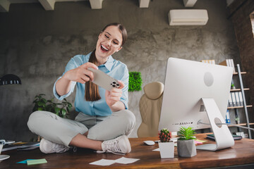 Photo of sweet charming lady assistant wear shirt glasses sitting table enjoying game modern device indoors workplace workstation