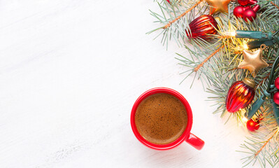 Red cup with coffee and fir branch with  Christmas decorations and glowing garland on old wooden shabby white table with empty space for text. Top view.