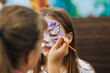 © shchus - Professional make-up artist, female artist draws with pencil, brush, watercolors, makes face painting for a beautiful girl, child for Halloween. Photography, portrait.