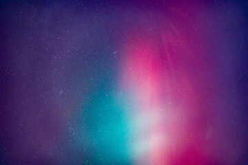 A purple and blue sky with stars. The sky is purple and blue with a greenish tint. An aurora borealis.