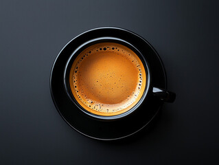 A top view of a freshly brewed espresso served in a black cup and saucer, set against a dark background