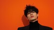 © Business Image - Stylish portrait of young man against vibrant orange background for fashion and media design
