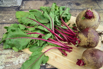 Bunch of fresh beetroots with leaves on wooden board