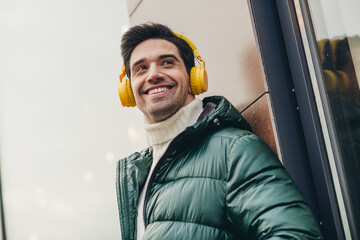 Poster - Photo of young attractive man listening music playlist walk promenade city autumn day outdoors