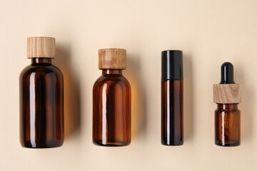 Canvas Print - Essential oils in bottles on beige background, flat lay