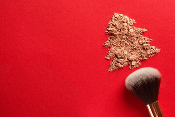 Poster - Christmas tree made of face powder and brush on red background, top view. Space for text