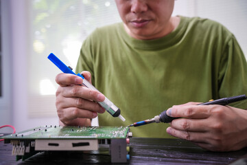 Engineer, a precise computer motherboard repair technician, uses a screwdriver to change parts, focuses on technology maintenance, repairs electronic devices, and supports ideas.