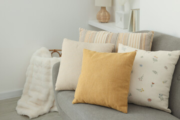 Poster - Different soft pillows on sofa in room